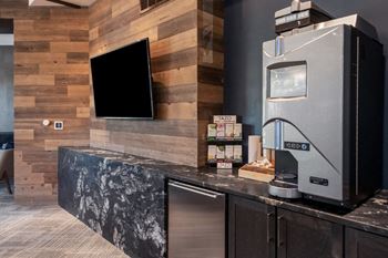 a kitchen with a counter and a refrigerator and a television